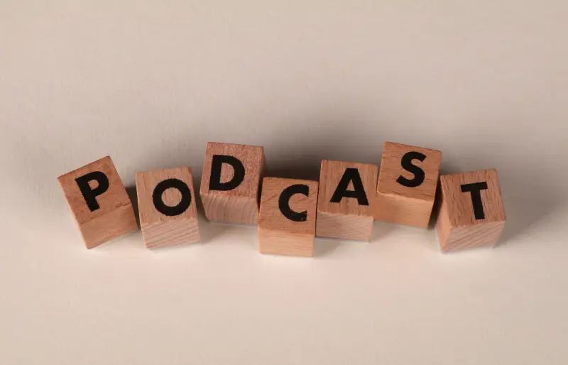 Holzwürfel, die nebeneinander liegen und das Wort "Podcast" bilden Holzwürfel, die nebeneinander liegen und das Wort "Podcast" bilden