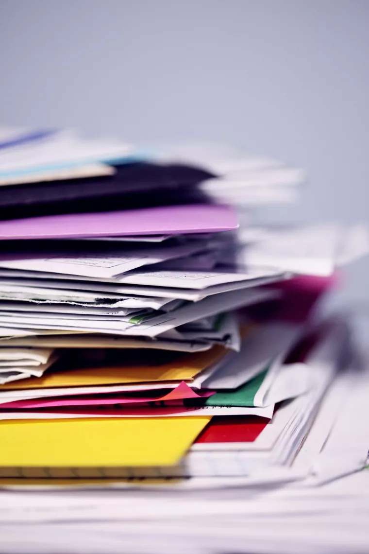 Ein Stapel mit Papier, Briefen und Arbeitsmappen.