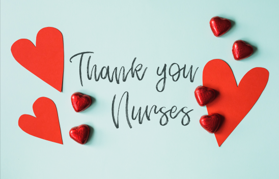 Auf einem hellblauen Hintergrund steht die schwarze Aufschrift "Thank you nurses". Drum herum liegen rote Herzen aus Pappe und Schokolade.