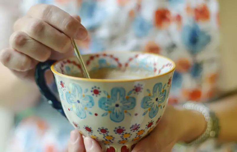 Ein Persön rührt in einer Teetasse.