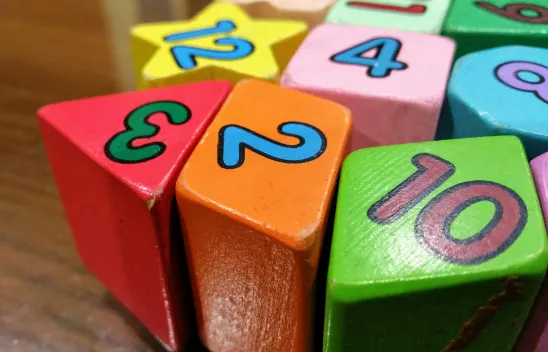 Bunte Spiel-Bauklötze in den Farben rot, orange, grün, rosa, hellblau und gelb. Darauf stehen jeweils Zahlen. Bunte Spiel-Bauklötze in den Farben rot, orange, grün, rosa, hellblau und gelb. Darauf stehen jeweils Zahlen.