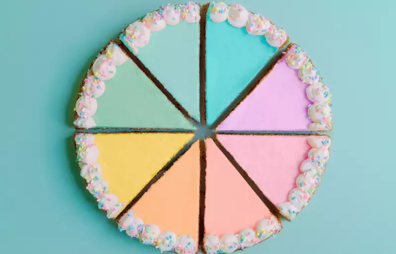 Ein Kuchen ist aufgeschnitten in Kuchenstücke in unterschiedlichen Farben.