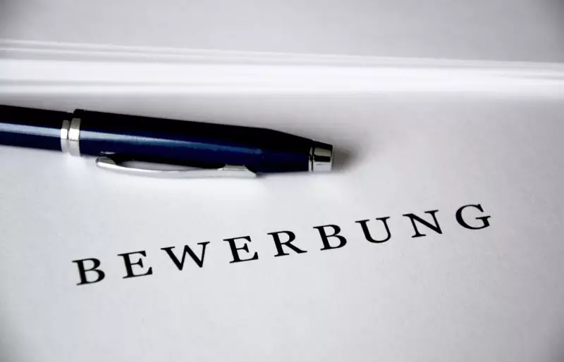 Schriftzug "Bewerbung" auf einem Blatt Papier, darüber liegt ein Kugelschreiber Schriftzug "Bewerbung" auf einem Blatt Papier, darüber liegt ein Kugelschreiber