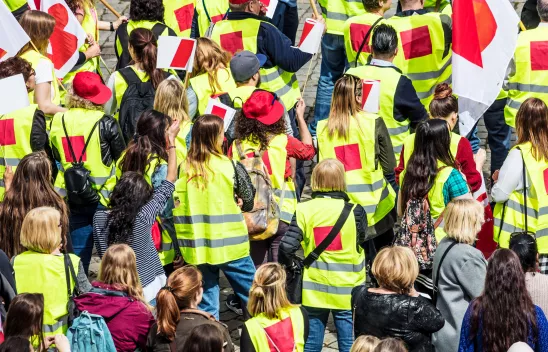 Menschen mit Warnwesten auf einer Demonstration einer Gewerkschaft Menschen mit Warnwesten auf einer Demonstration einer Gewerkschaft
