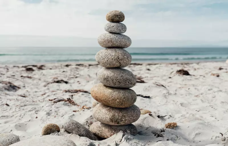 Ein Stapel balancierender Steine an einem Strand.
