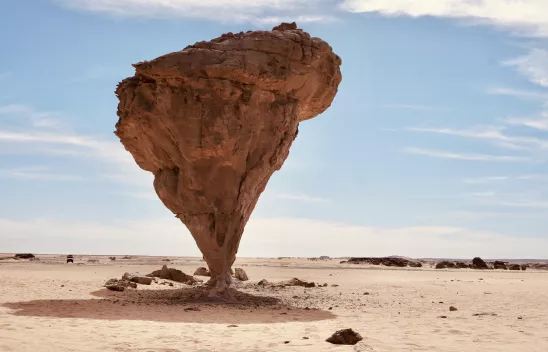 Das Bild zeigt einen erodierten Felsen in der Wüste, der nach unten spitz zuläuft und an eine extreme Form der "Bevölkerungspyramide" erinnert.