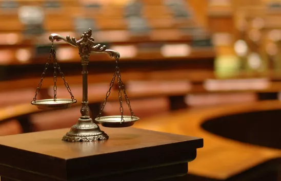 Eine Waage in einem Gerichtssaal als Symbolbild für Gerechtigkeit.