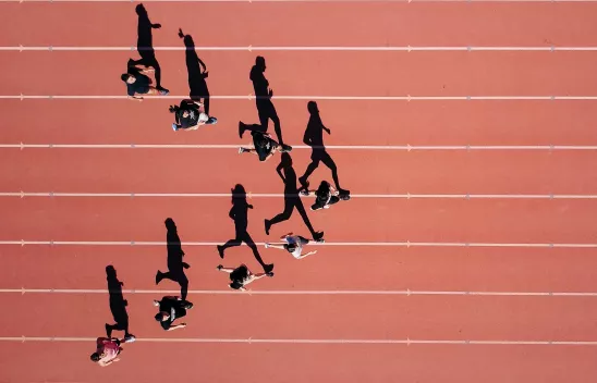 Eine Gruppe Läufer*innen auf einer Laufbahn.