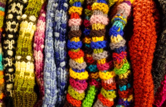 Strickzeug aus bunter Wolle als Sinnbild für die Verwobenheit sozialer Kategorien aus intersektionaler Perspektive. Strickzeug aus bunter Wolle als Sinnbild für die Verwobenheit sozialer Kategorien aus intersektionaler Perspektive.