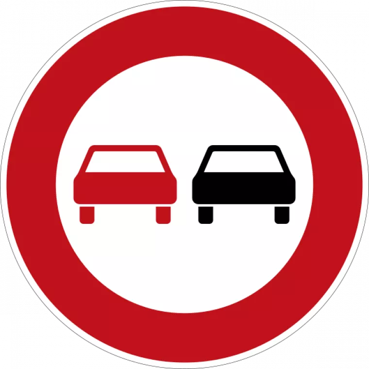 Ein Überholverbotsschild: Ein roter Kreis in dem links ein rotes Auto und rechts ein schwarzes Auto abgebildet sind. 