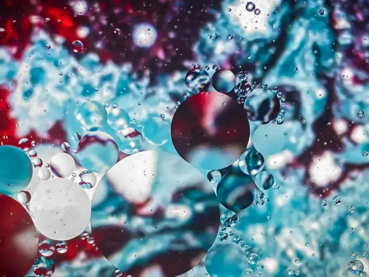Eine Nahaufnahme von blauem Wasser und Blasen auf einer Oberfläche symbolisiert Gruppen und Netzwerke, die der Artikel aufdeckt.