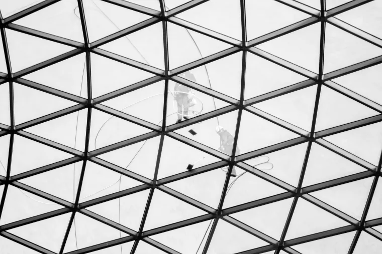 Zwei Arbeiter*innen beim Reinigen einer Glasfassade