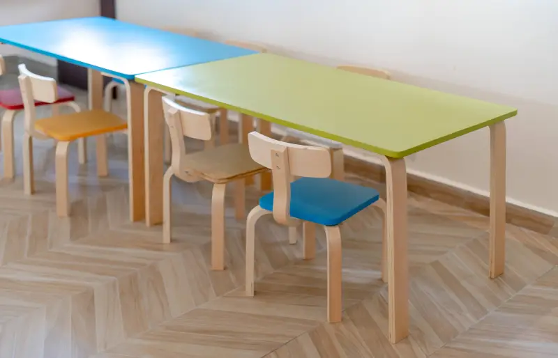 Mehrere Kinderstühle stehen auf dem Boden vor mehreren Kindertischen Mehrere Kinderstühle stehen auf dem Boden vor mehreren Kindertischen