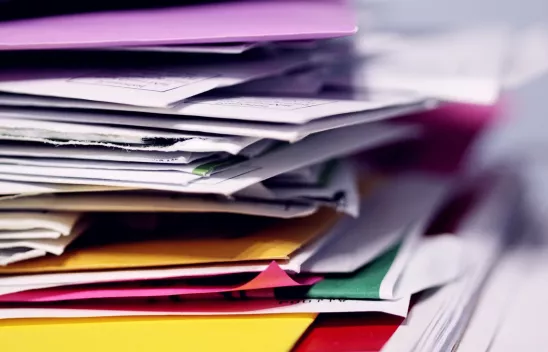 Ein Stapel mit Papier, Briefen und Arbeitsmappen.
