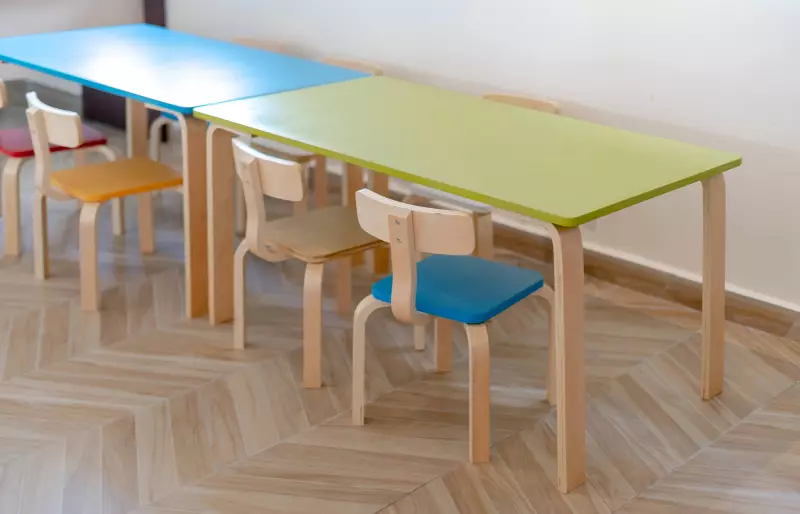 Mehrere bunte Kinderstühle stehen vor kleinen Kindertischen Mehrere bunte Kinderstühle stehen vor kleinen Kindertischen