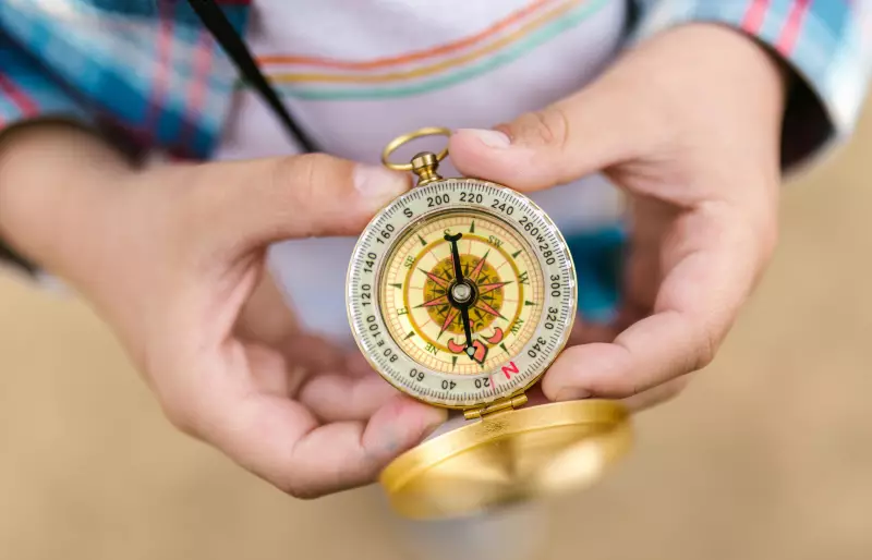 Eine Person hält einen Kompass in den Händen. Eine Person hält einen Kompass in den Händen.